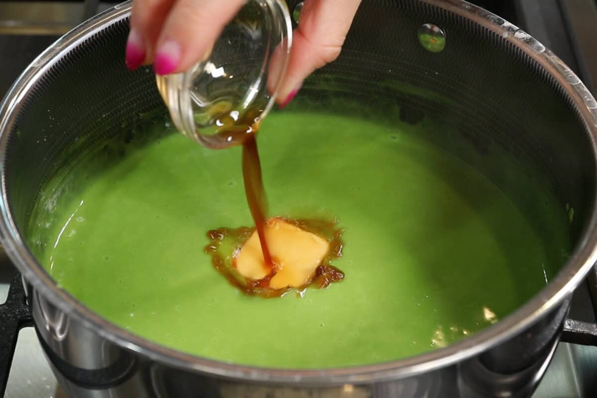 adding vegan butter, vanilla and salt to matcha custard in pot for Vegan Matcha Crème Brûlée