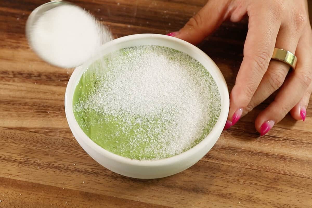 adding sugar on top of matcha custard in ramekin for Vegan Matcha Crème Brûlée