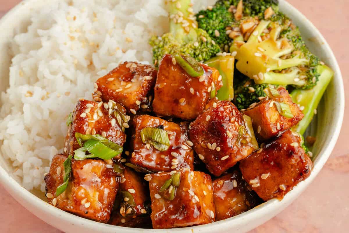 close up image of a bowl filled with maple glazed tofu, broccoli, and rice