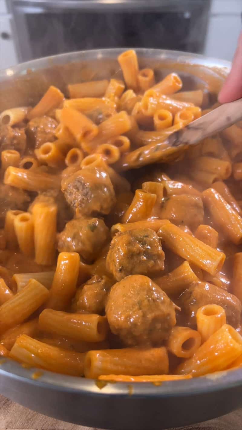 mixing creamy marinara pasta in pan