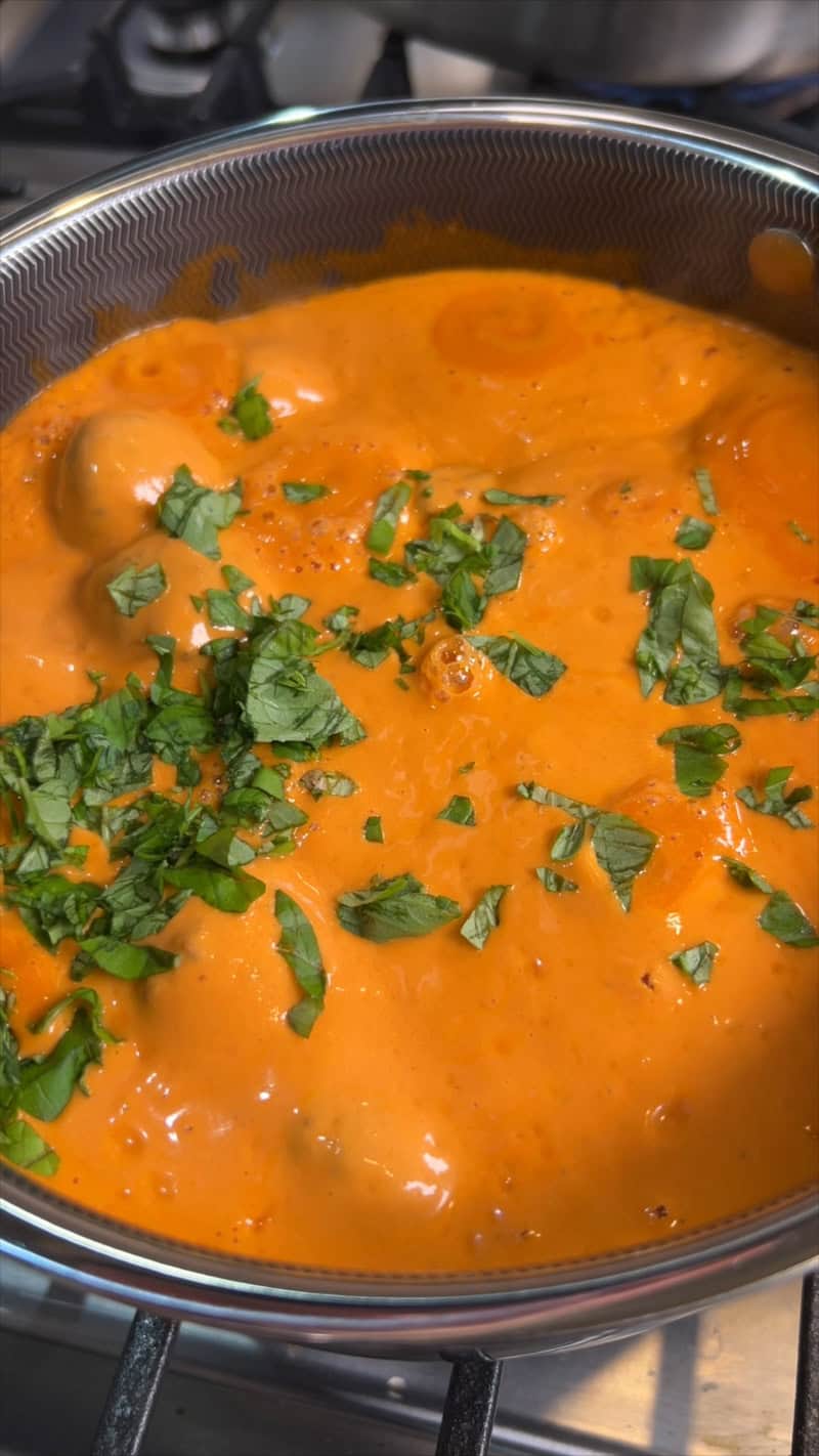 adding basil to pasta sauce