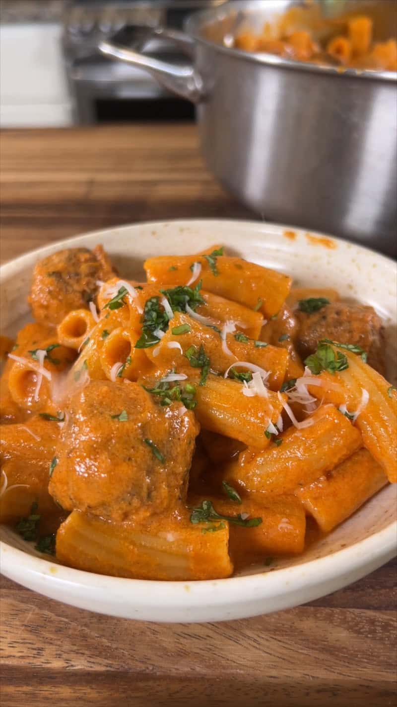 bowl of creamy marinara pasta topped with basil and parm