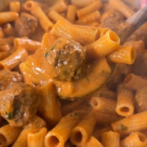 finished pasta with meatballs being scooped with a spoon