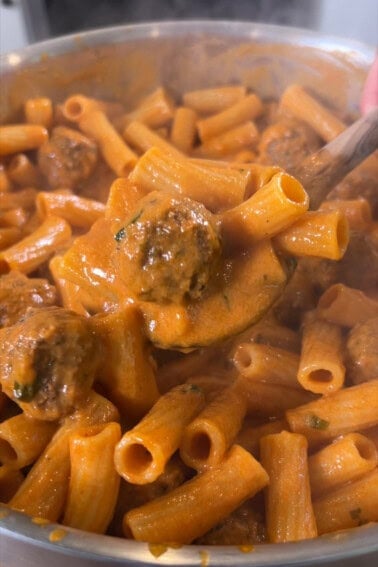 finished pasta with meatballs being scooped with a spoon