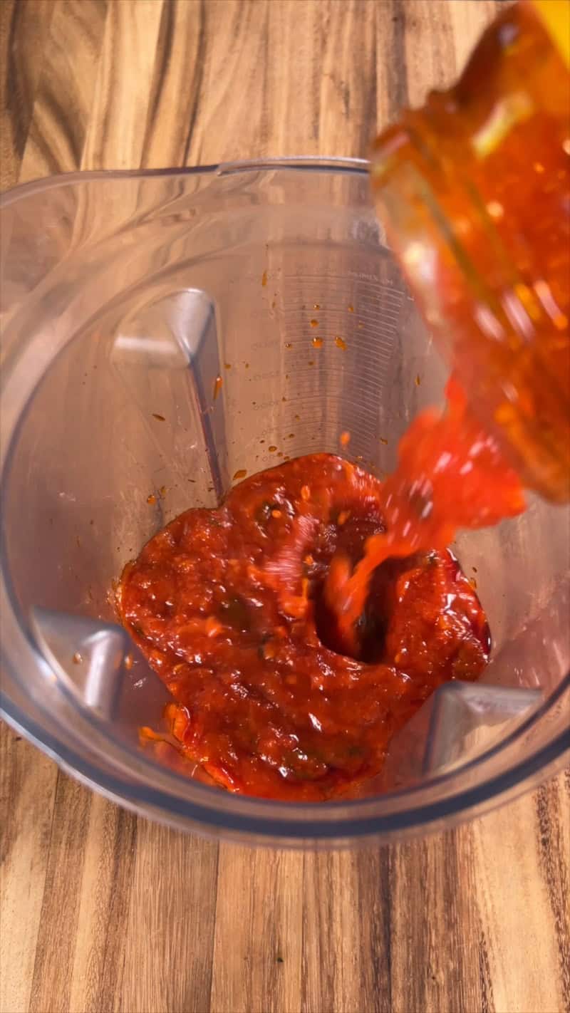 adding marinara sauce to blender