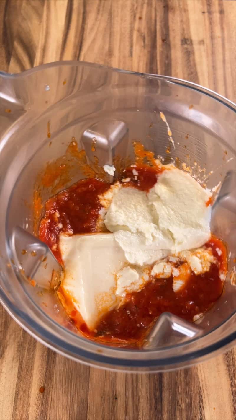 adding garlic spread into blender for sauce
