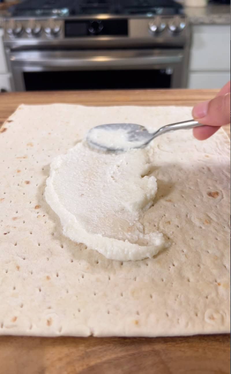 adding garlic spread to wrap