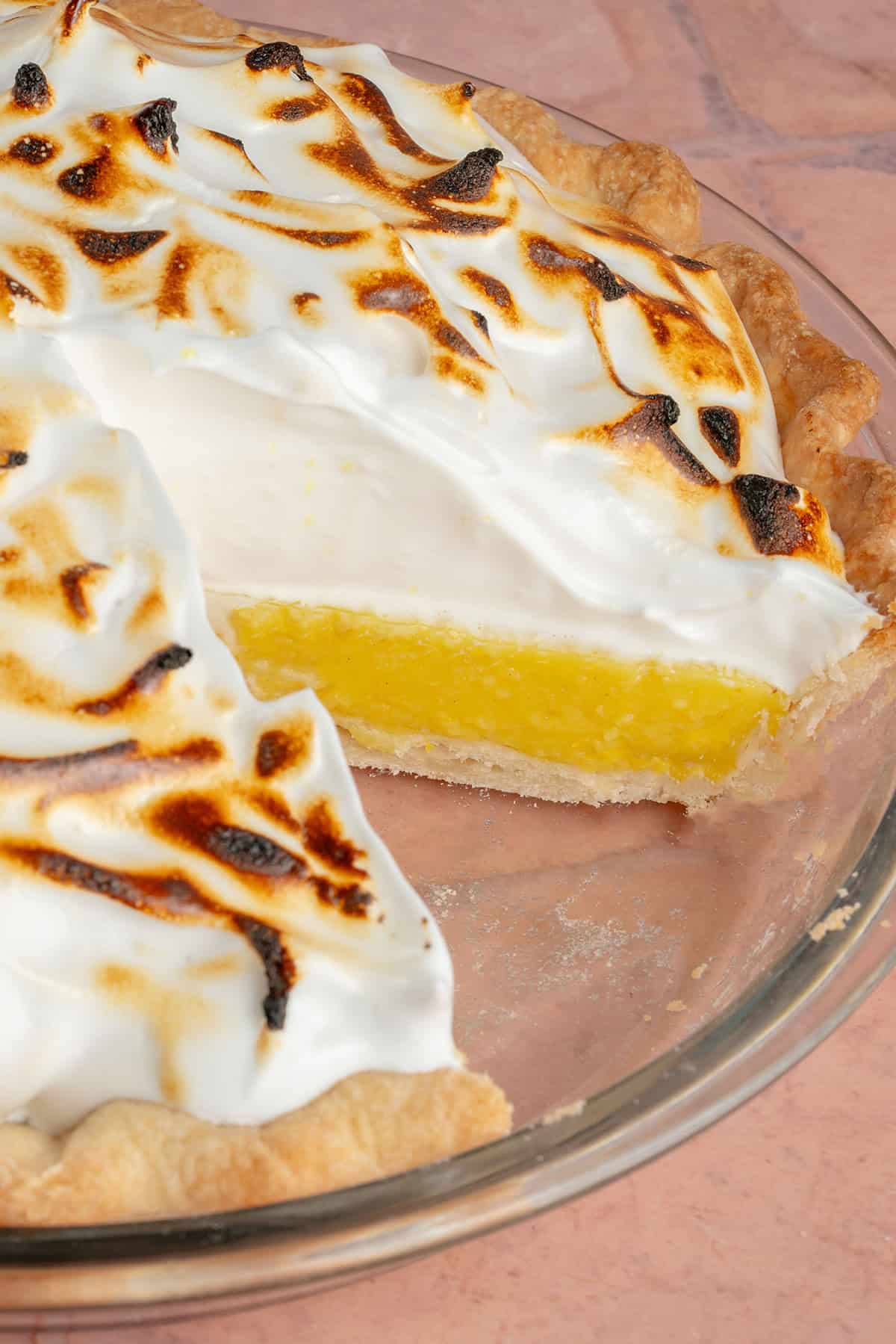 inside of a sliced vegan lemon meringue pie in glass pie pan