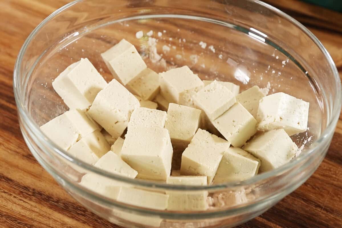 cubed tofu in a bowl with cornstarch and spices