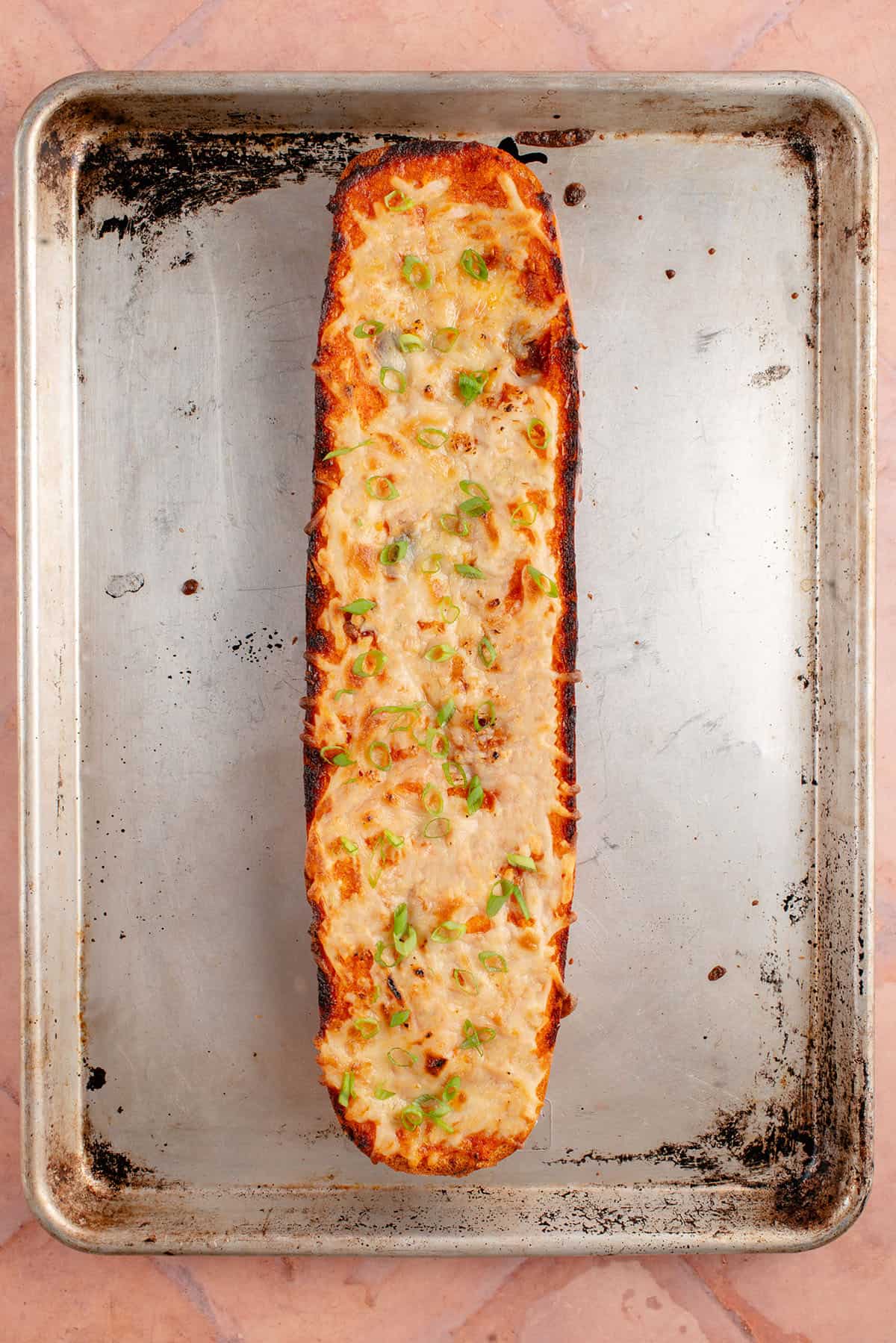 half a loaf of gochujang garlic bread on a baking sheet