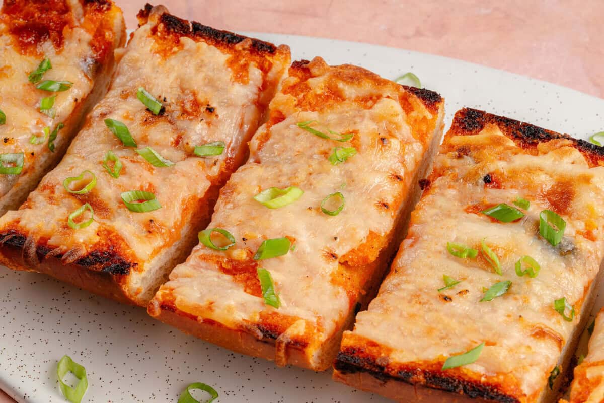 sliced cheesy gochujang garlic bread topped with green onions
