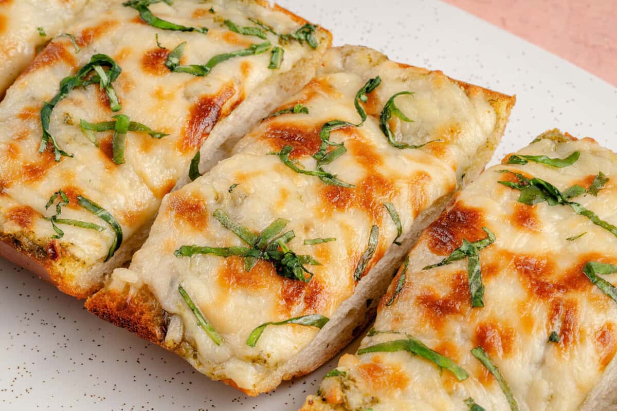 cheesy pesto garlic bread on a plate