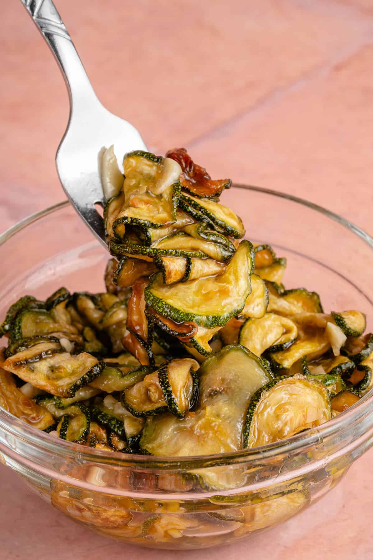 A bowl of zucchini with a spoon.