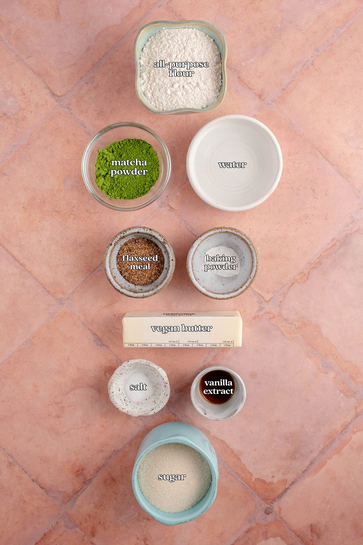 labeled ingredients for vegan matcha sugar cookies: all-purpose flour, matcha powder, water, flaxseed meal, baking powder, vegan butter, salt, vanilla extract, and sugar