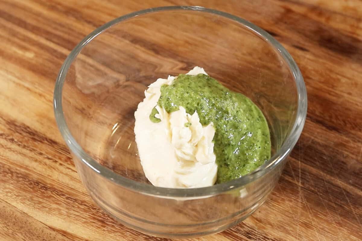 combining pesto and vegan butter in a bowl