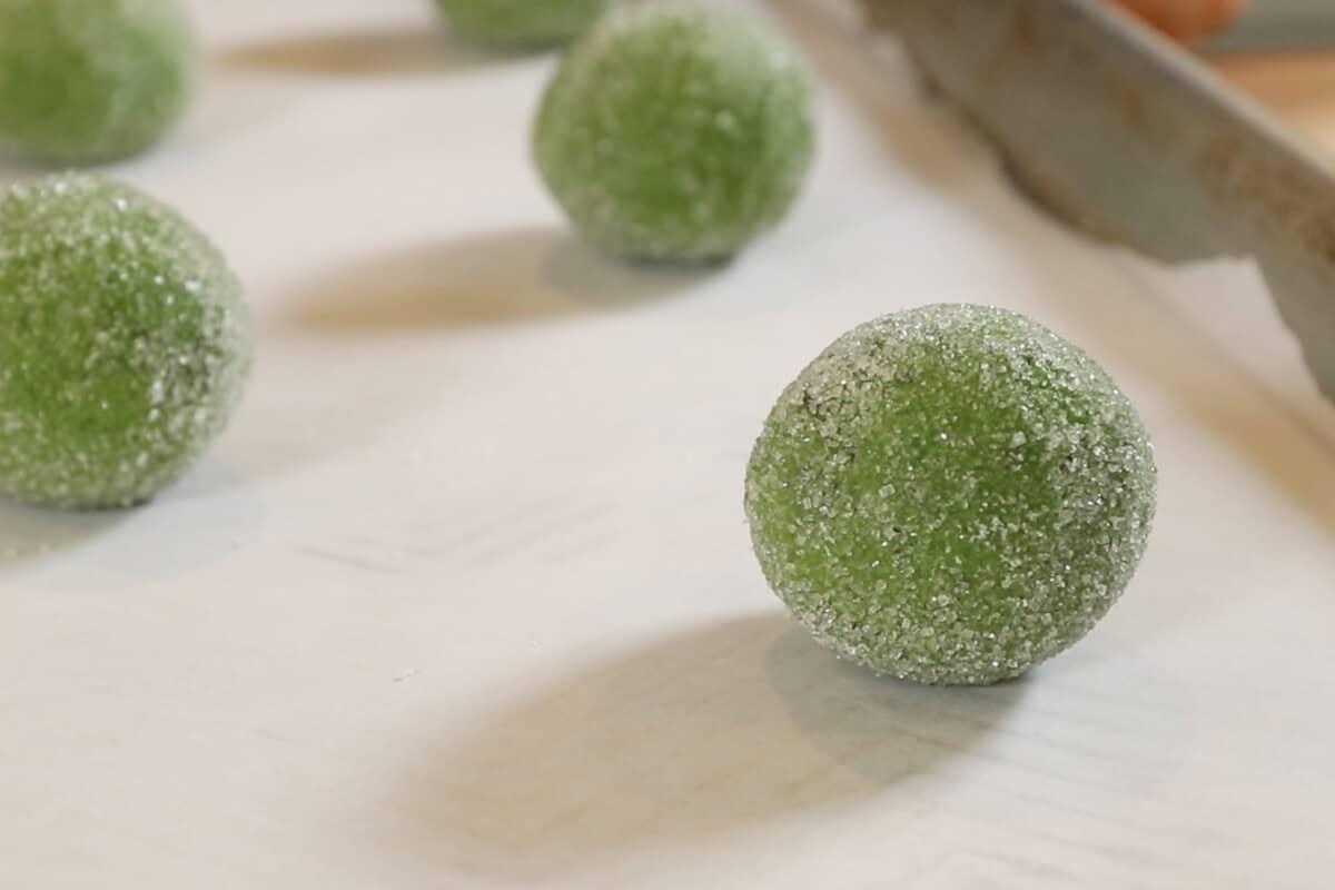 unbaked vegan matcha sugar cookie dough on a parchment lined baking sheet