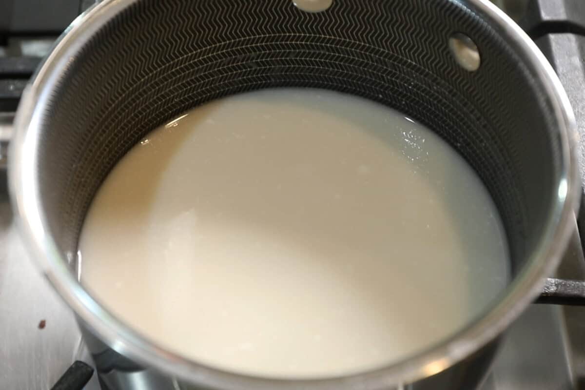 melting sugar into coconut milk for mango sticky rice recipe
