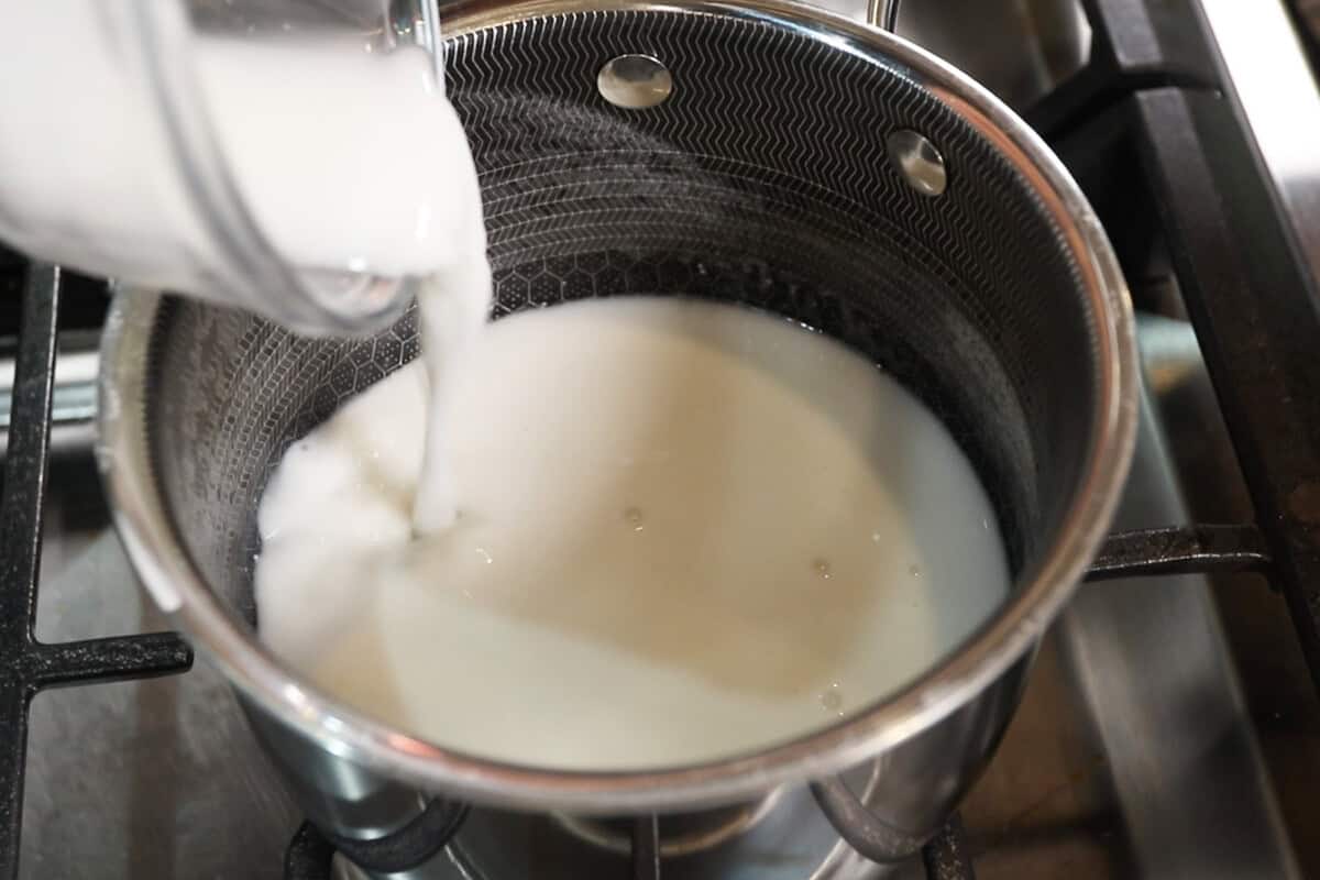 preparing sweet coconut cream sauce for mango sticky rice