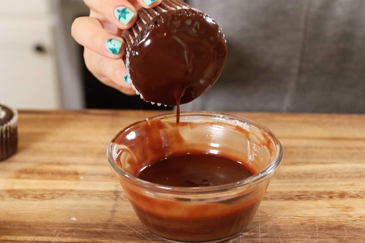 letting the chocolate topping drip off the cupcake