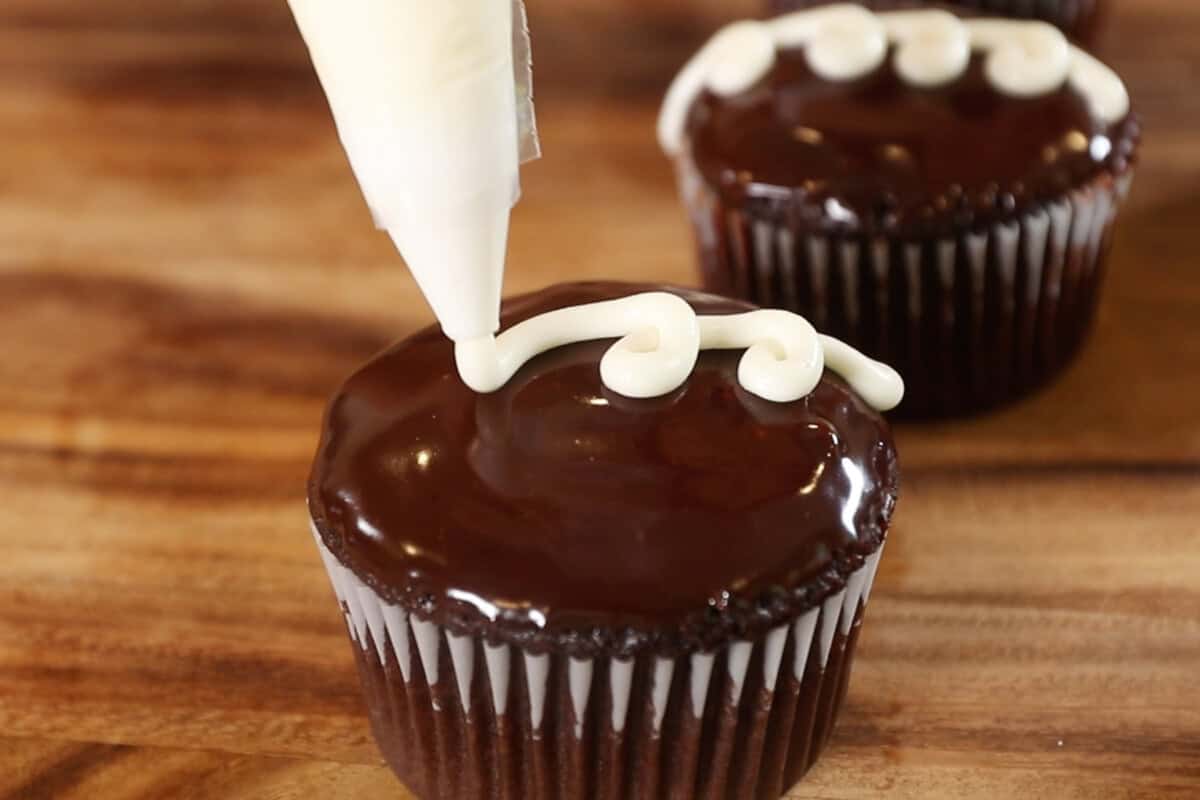 decorating the cupcake with white icing