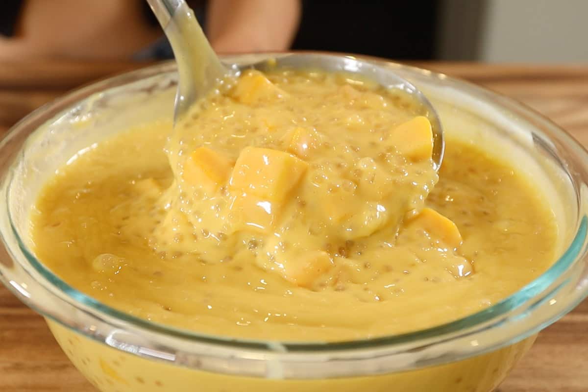 ladle with mango sago in large glass bowl