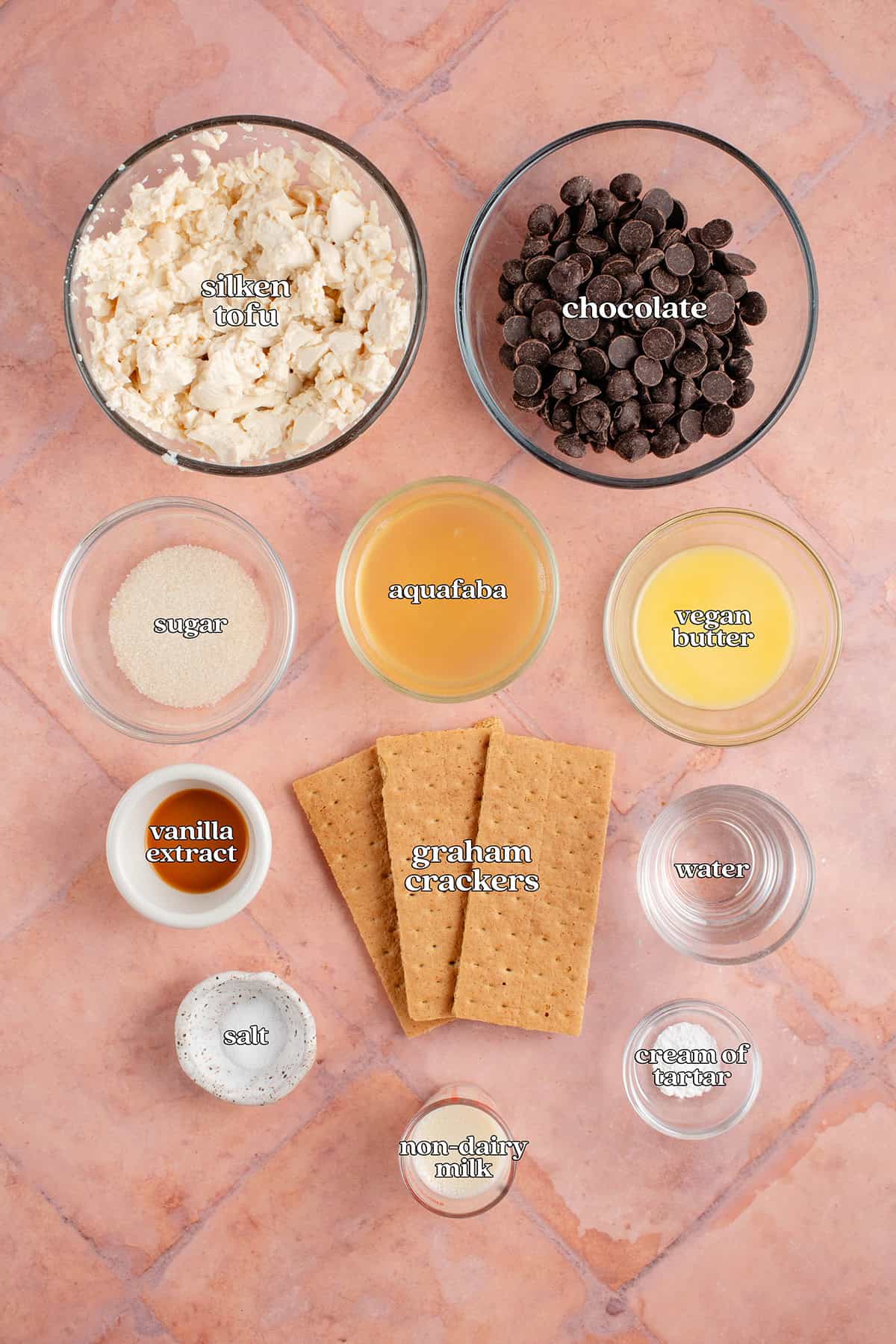 labeled ingredients for s'mores pie: silken tofu, chocolate, sugar, aquafaba, vegan butter, vanilla extract, graham crackers, water, salt, non-dairy milk, cream of tartar