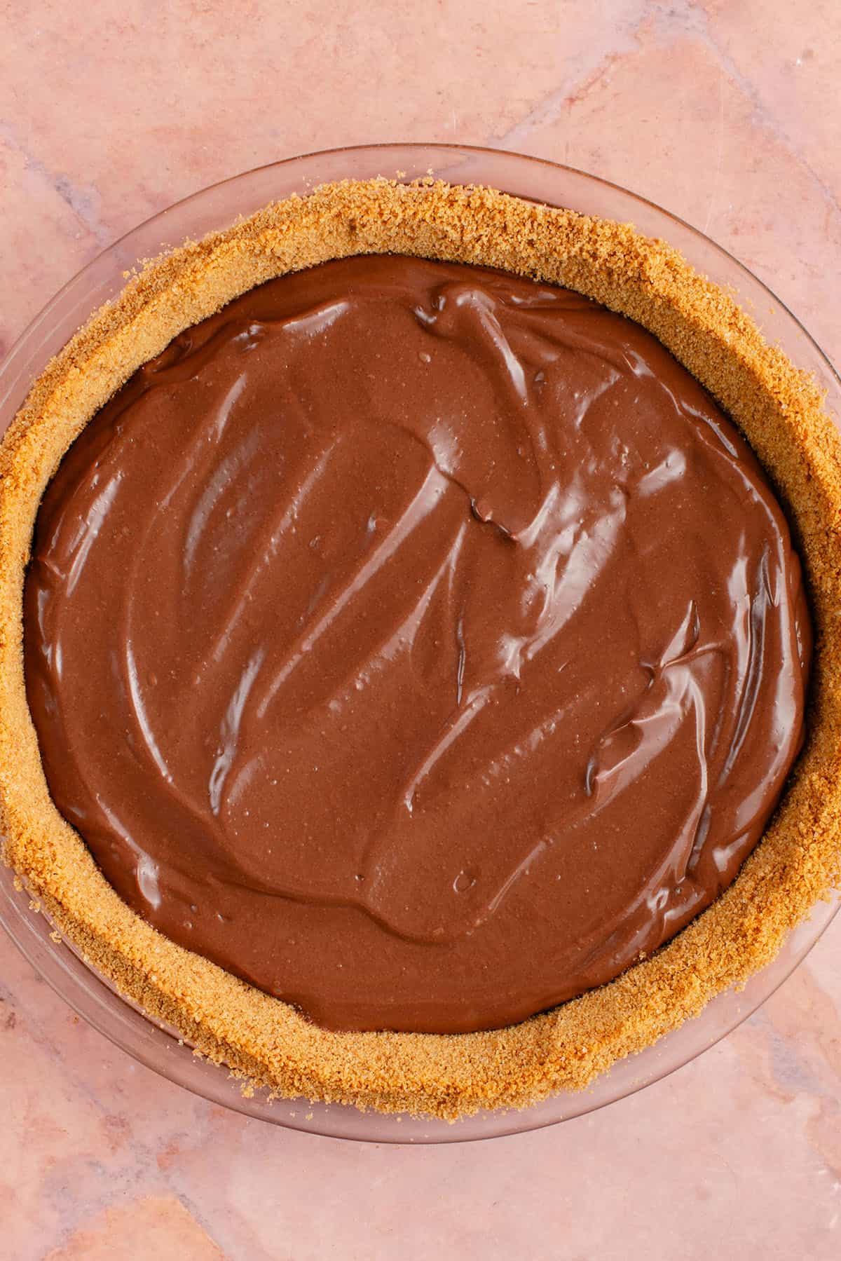 smooth chocolate filling on top of graham cracker pie crust for S'mores Pie