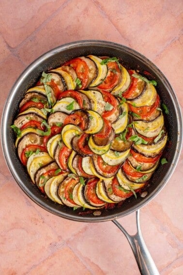 oven baked ratatouille in a pan on pink background