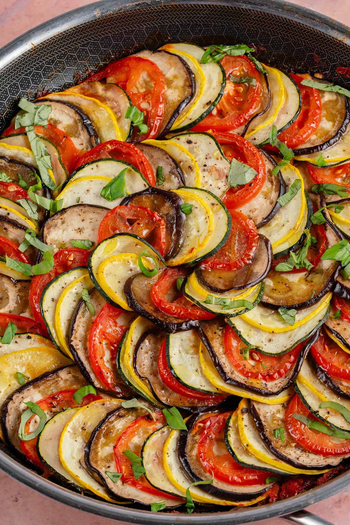oven baked ratatouille in a pan on pink background