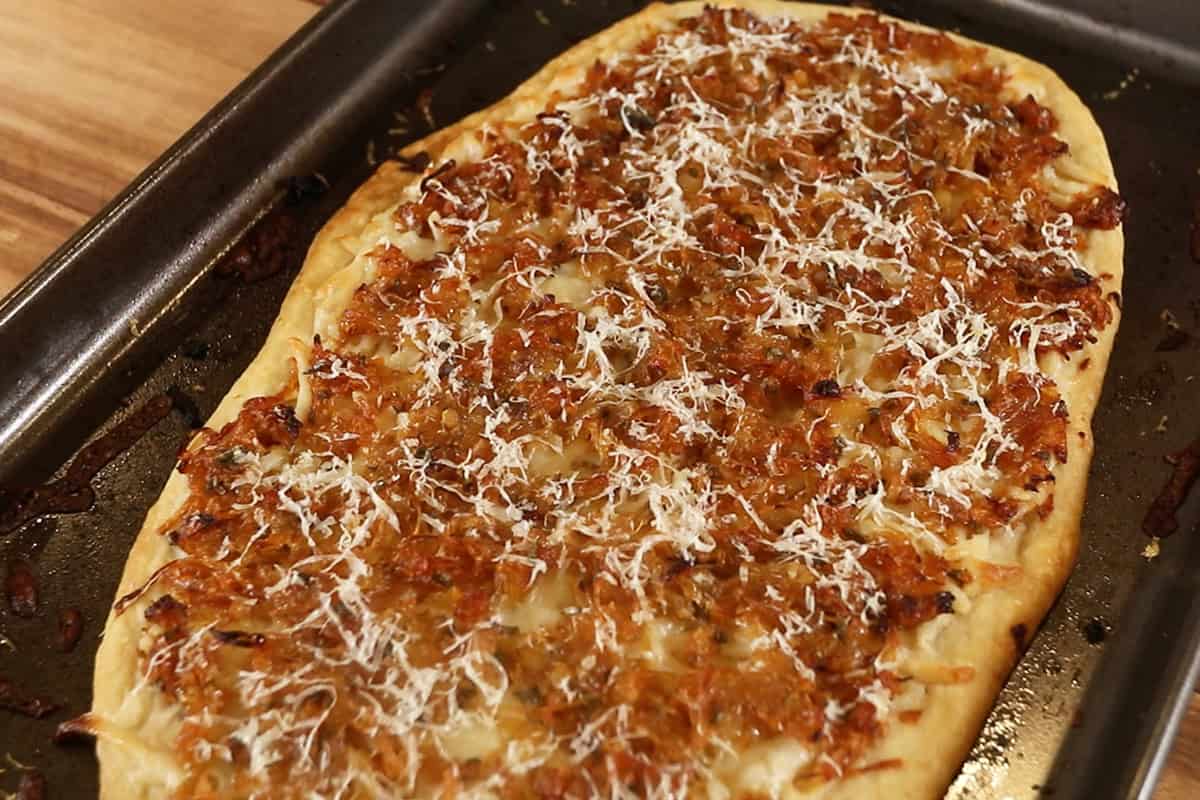 freshly baked Caramelized Onion Flatbread on dark baking sheet