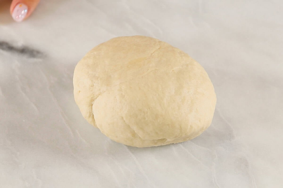 a ball of flatbread dough on marble surface