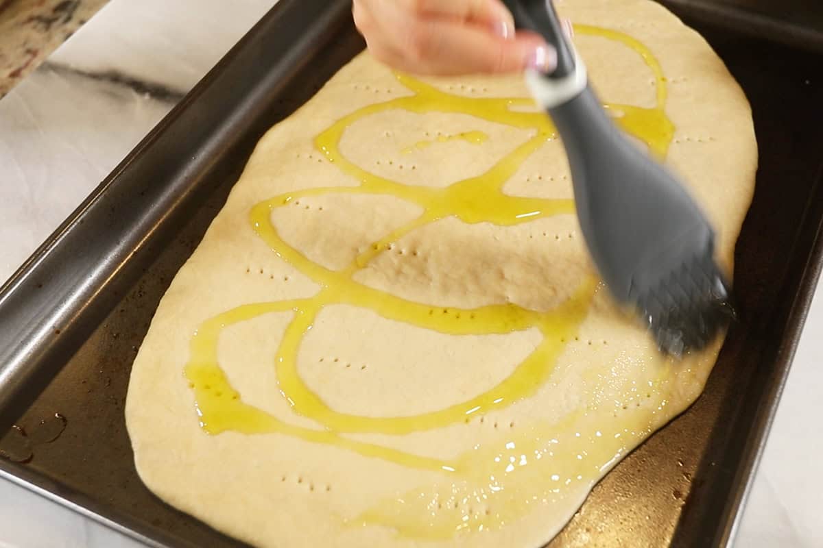 oiled plain Flatbread on dark baking sheet before baking