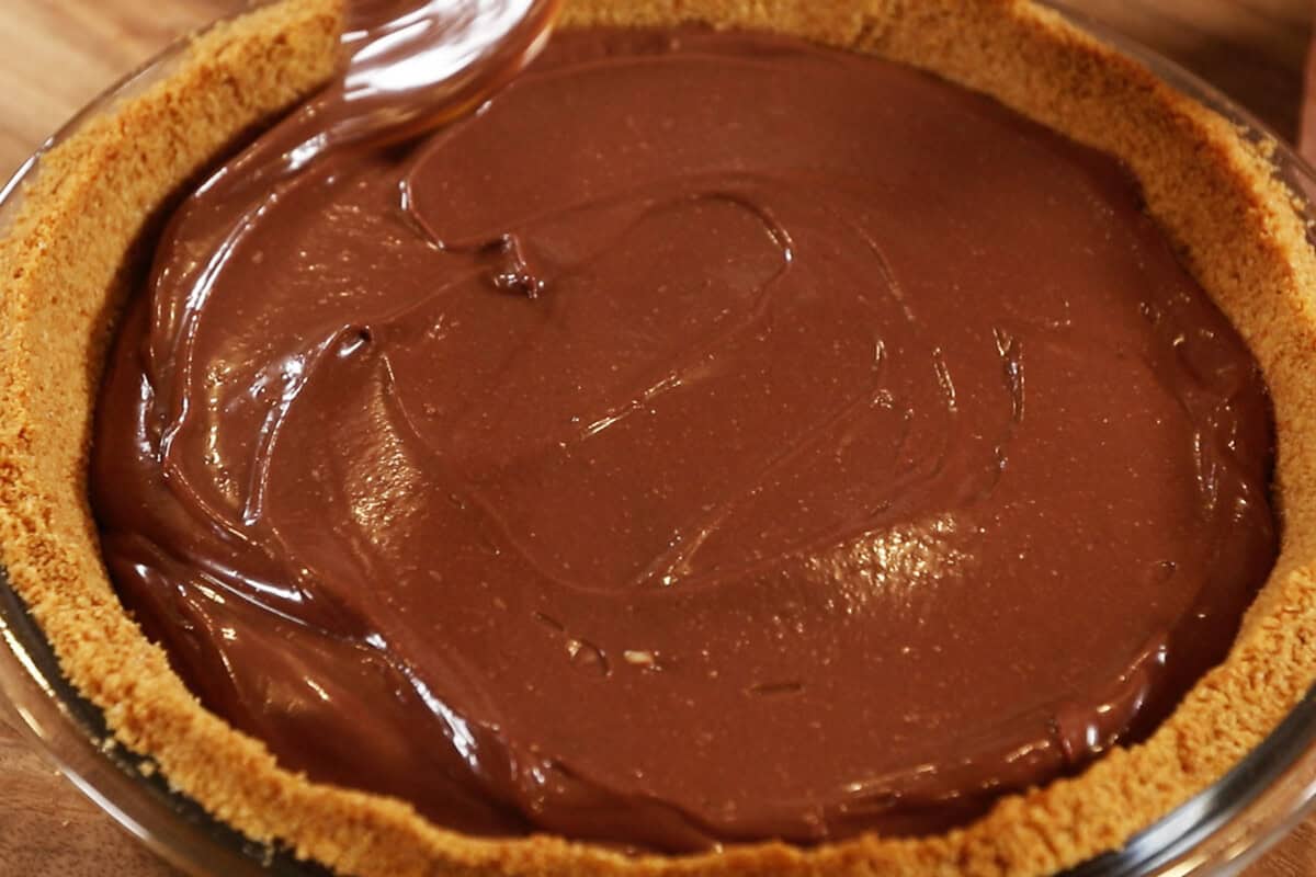 smooth chocolate filling on top of graham cracked pie crust for S'mores Pie