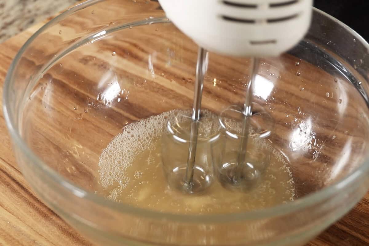 whipped aquafaba into vegan meringue in large glass bowl