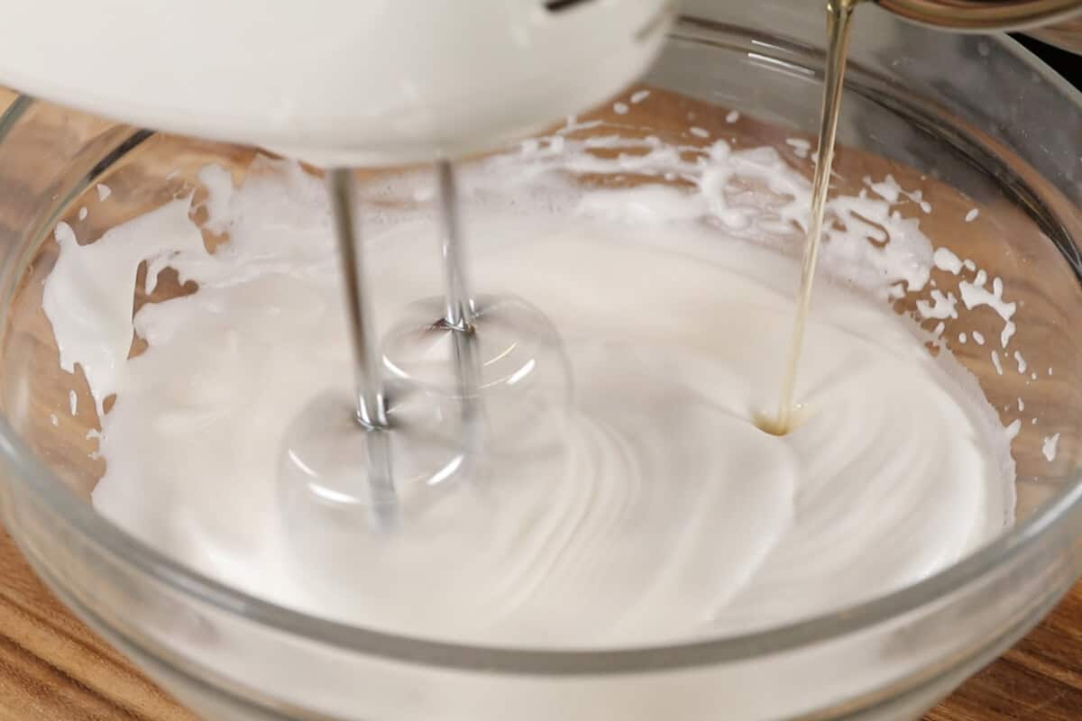 whipping vegan meringue in large glass bowl