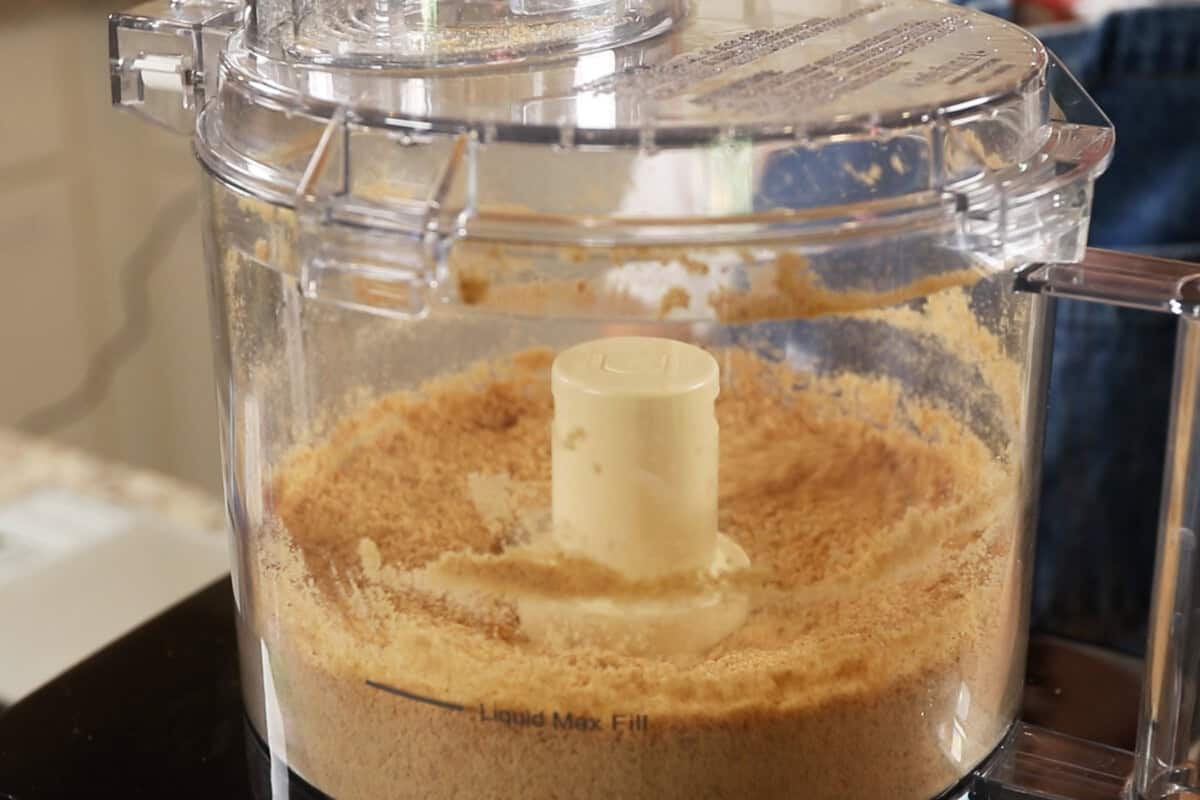 preparing a graham cracker crust in a food processor for S'mores Pie