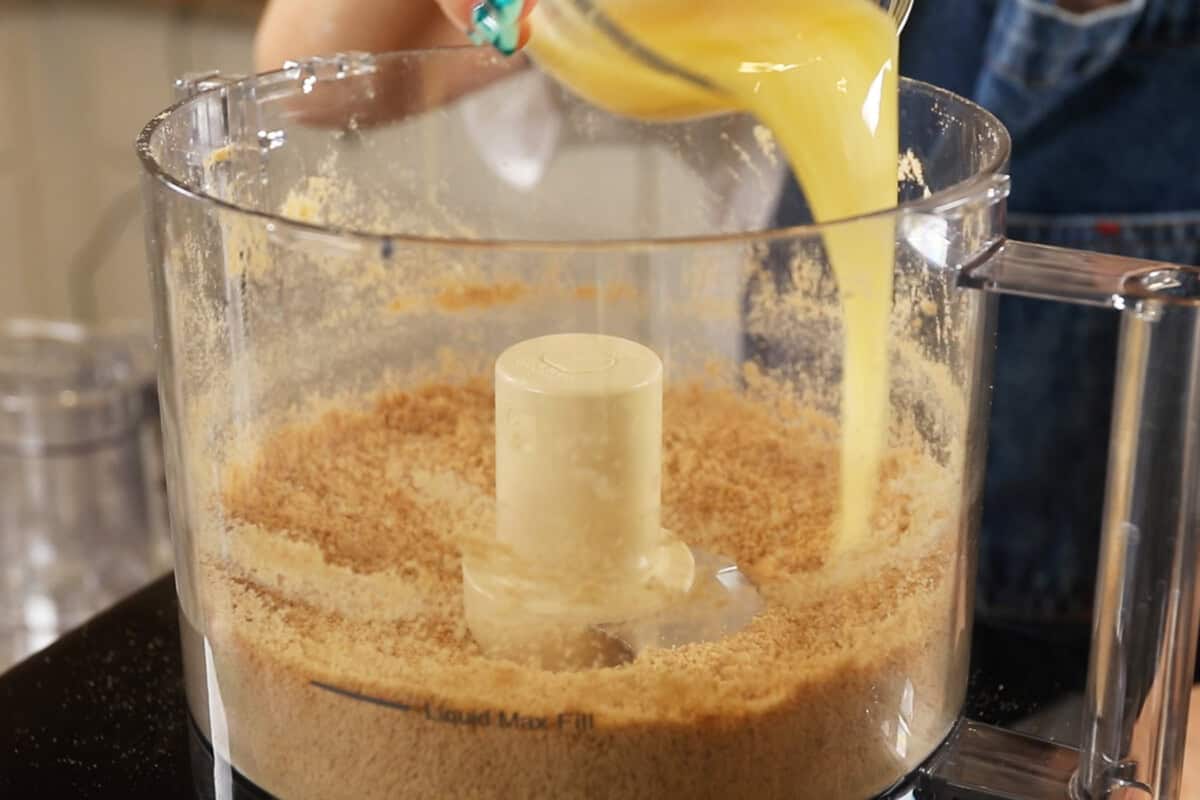 preparing a graham cracker crust in a food processor for S'mores Pie