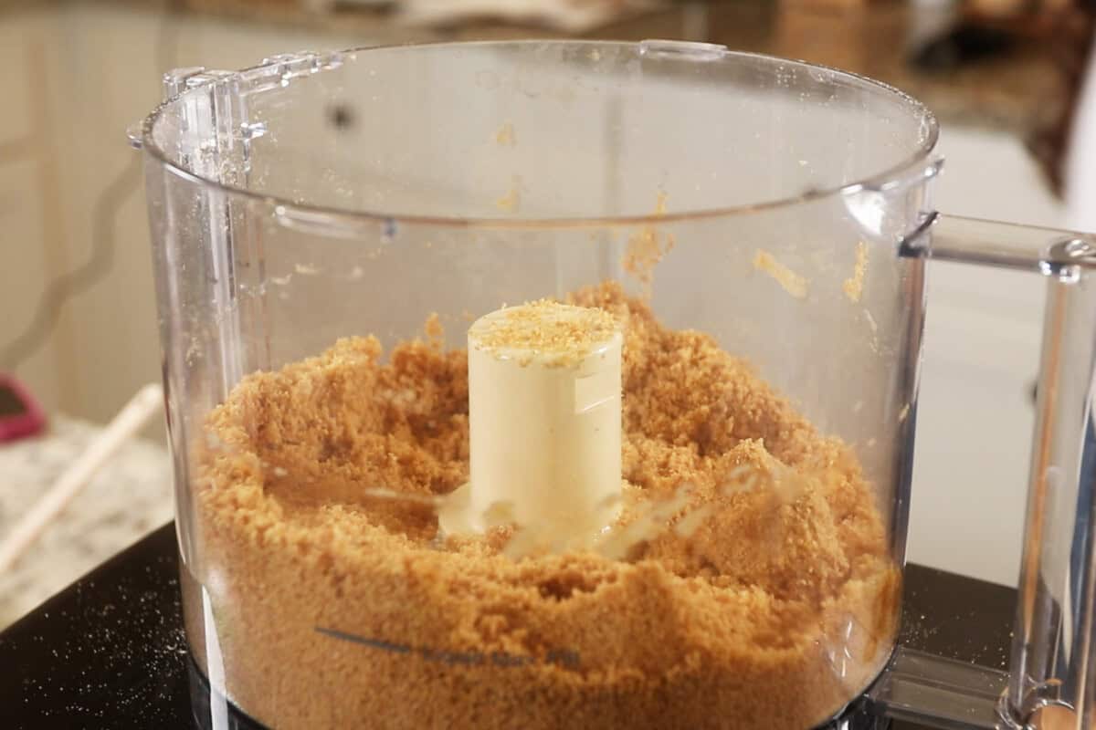 preparing a graham cracker crust in a food processor for S'mores Pie