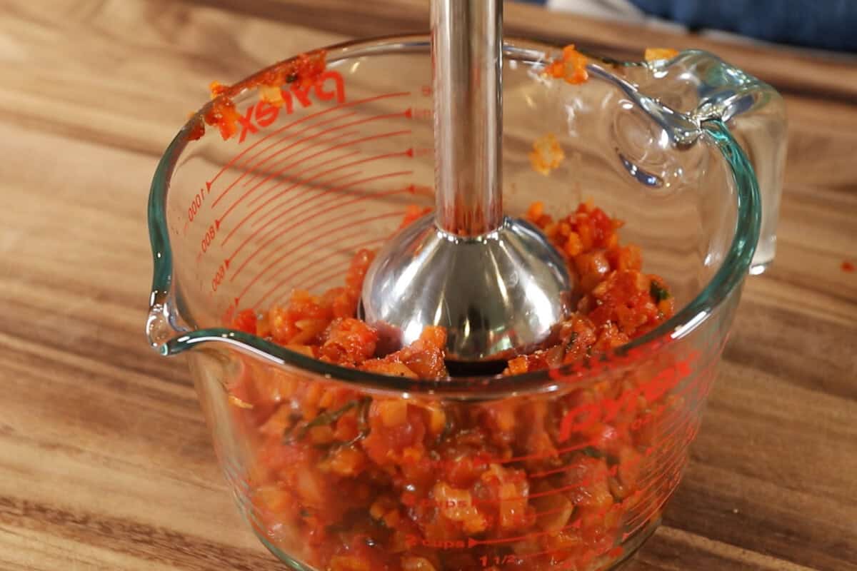 using an immersion blender to blend sauce