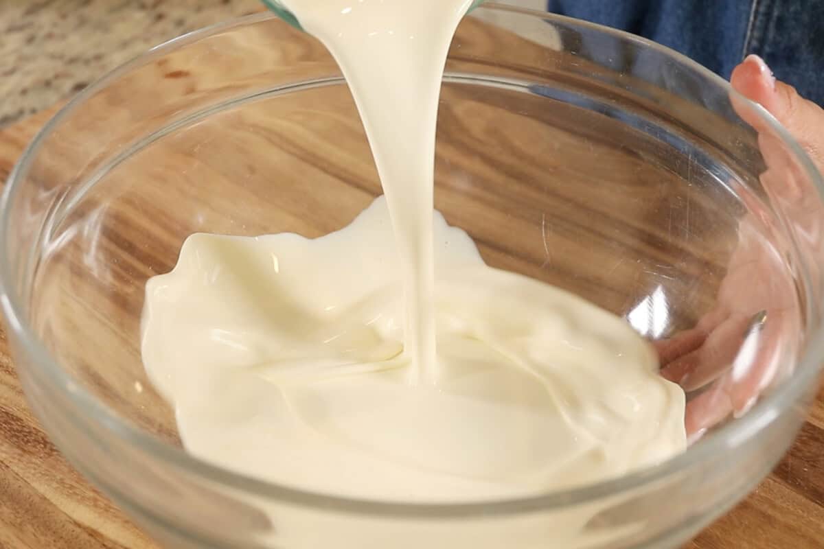 pouring heavy cream into large bowl