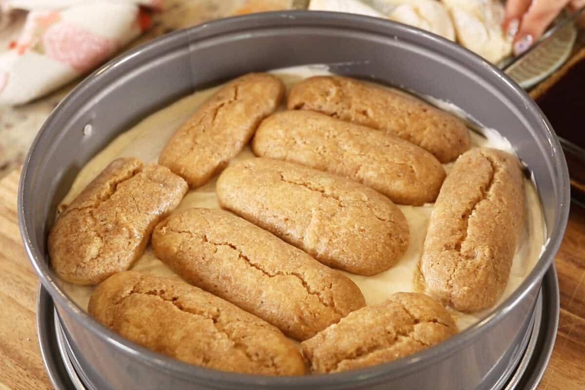 adding coffee soaked lady fingers to cake