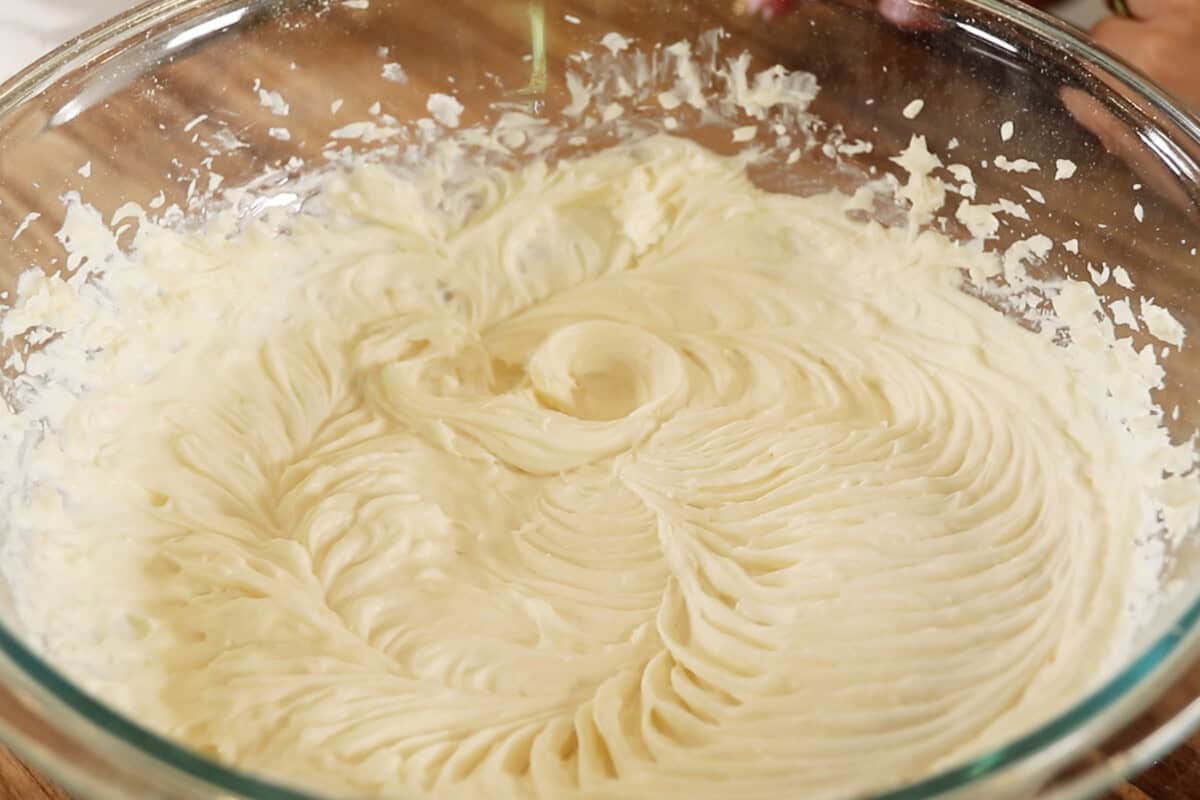 Buttered vegan frosting in a glass mixing bowl, creamy and smooth texture, perfect for vegan baking recipes.