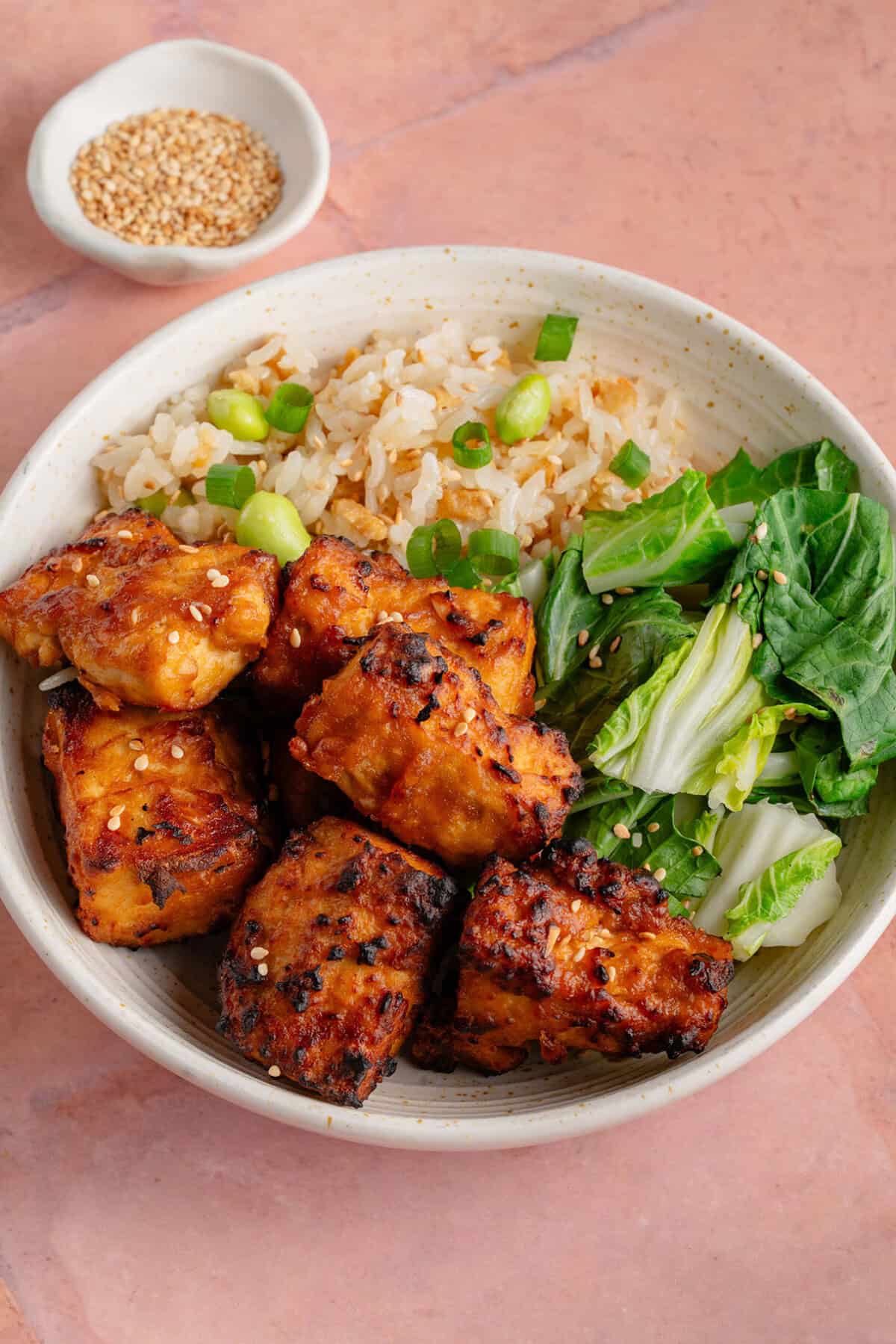 bowl of air fried miso sesame tofu with fried rice and greens