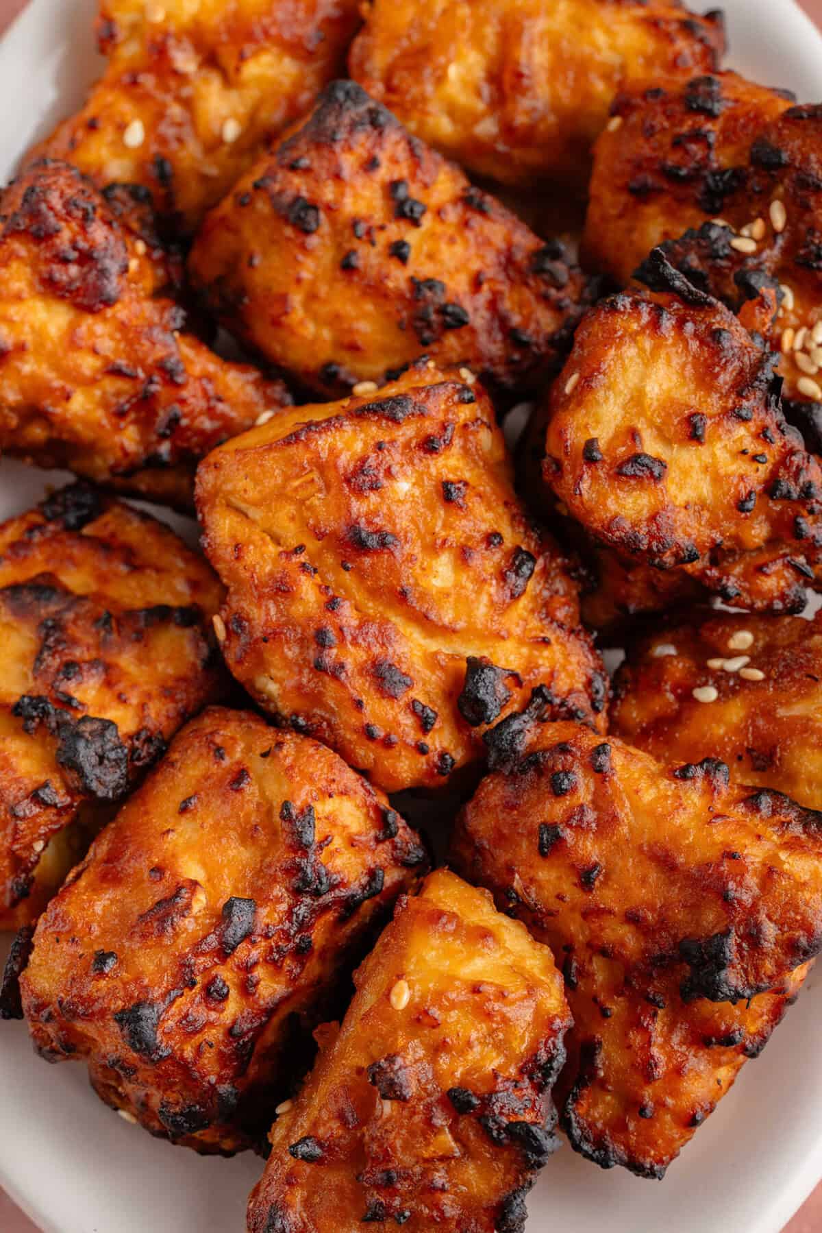 Crispy vegan tofu nuggets glazed with spicy sauce.