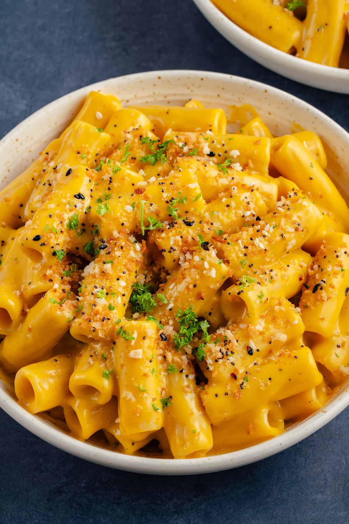 bowl of creamy vegan butternut squash mac and cheese topped with everything bagel panko bread crumbs and parsley