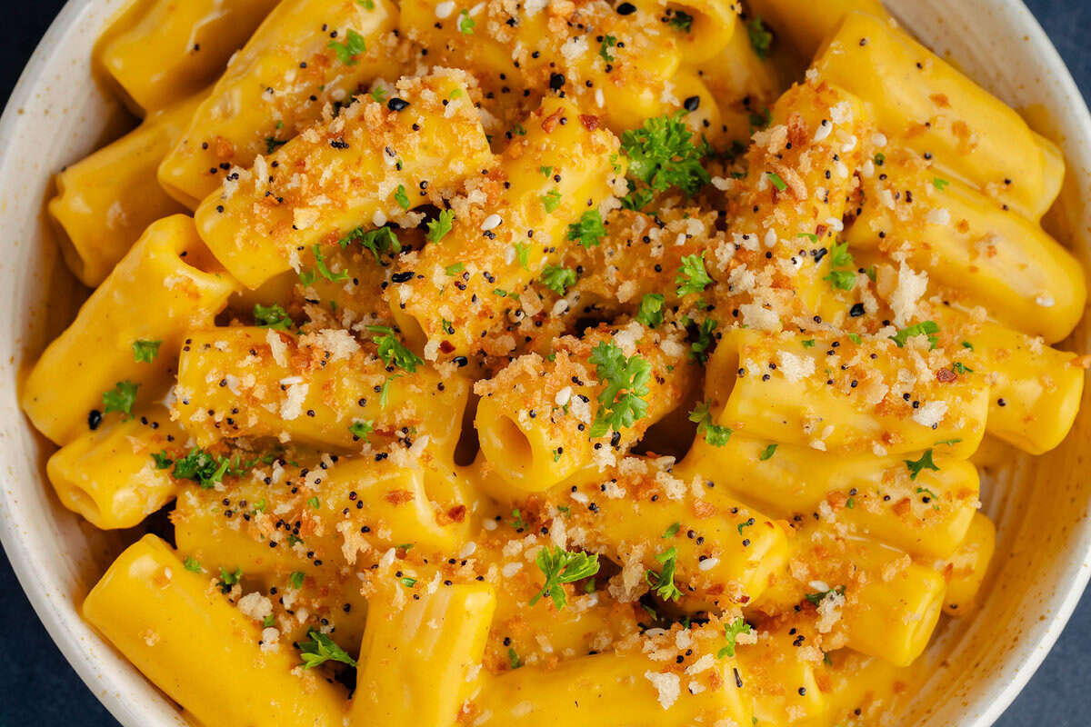 bowl of creamy vegan butternut squash mac and cheese topped with everything bagel panko bread crumbs and parsley
