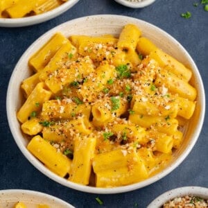 bowl of creamy vegan butternut squash mac and cheese topped with everything bagel panko bread crumbs and parsley