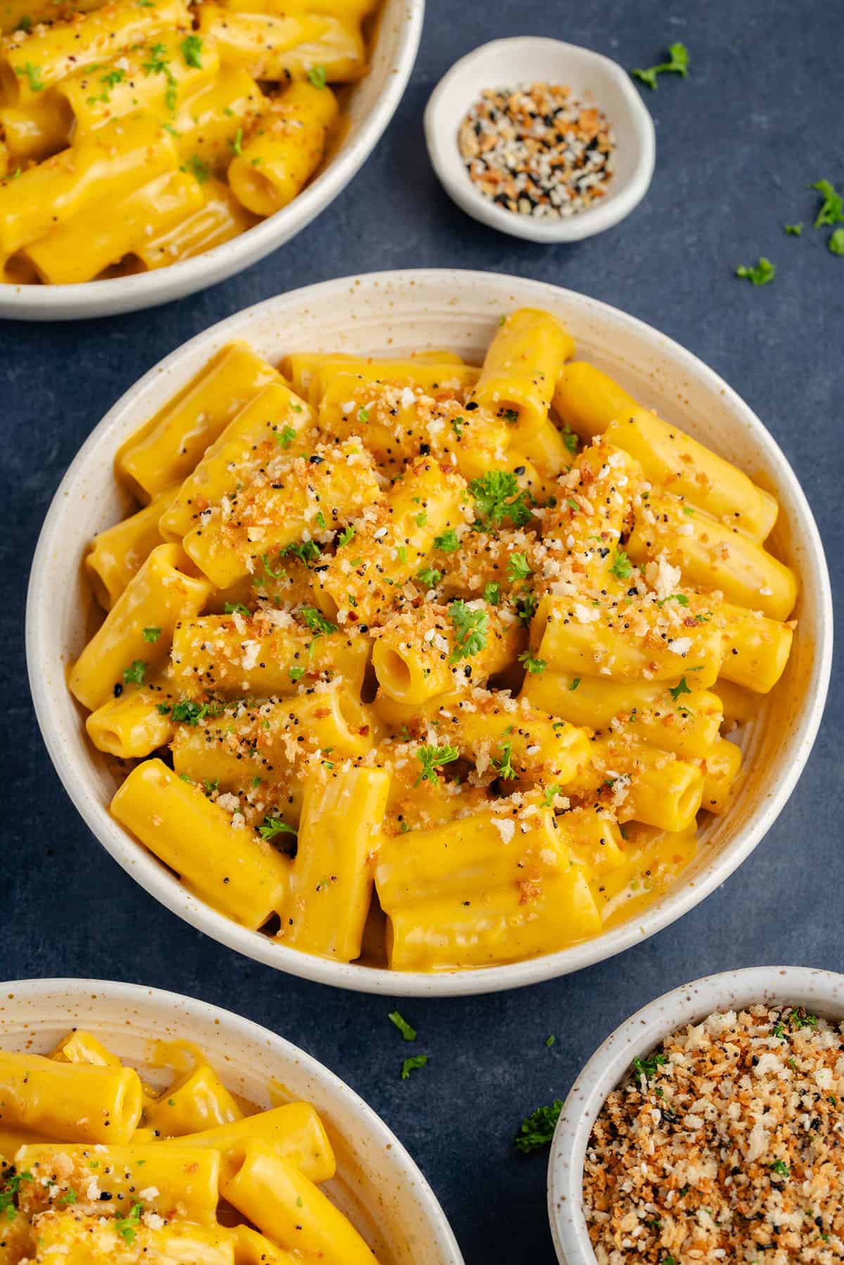 bowl of creamy vegan butternut squash mac and cheese topped with everything bagel panko bread crumbs and parsley
