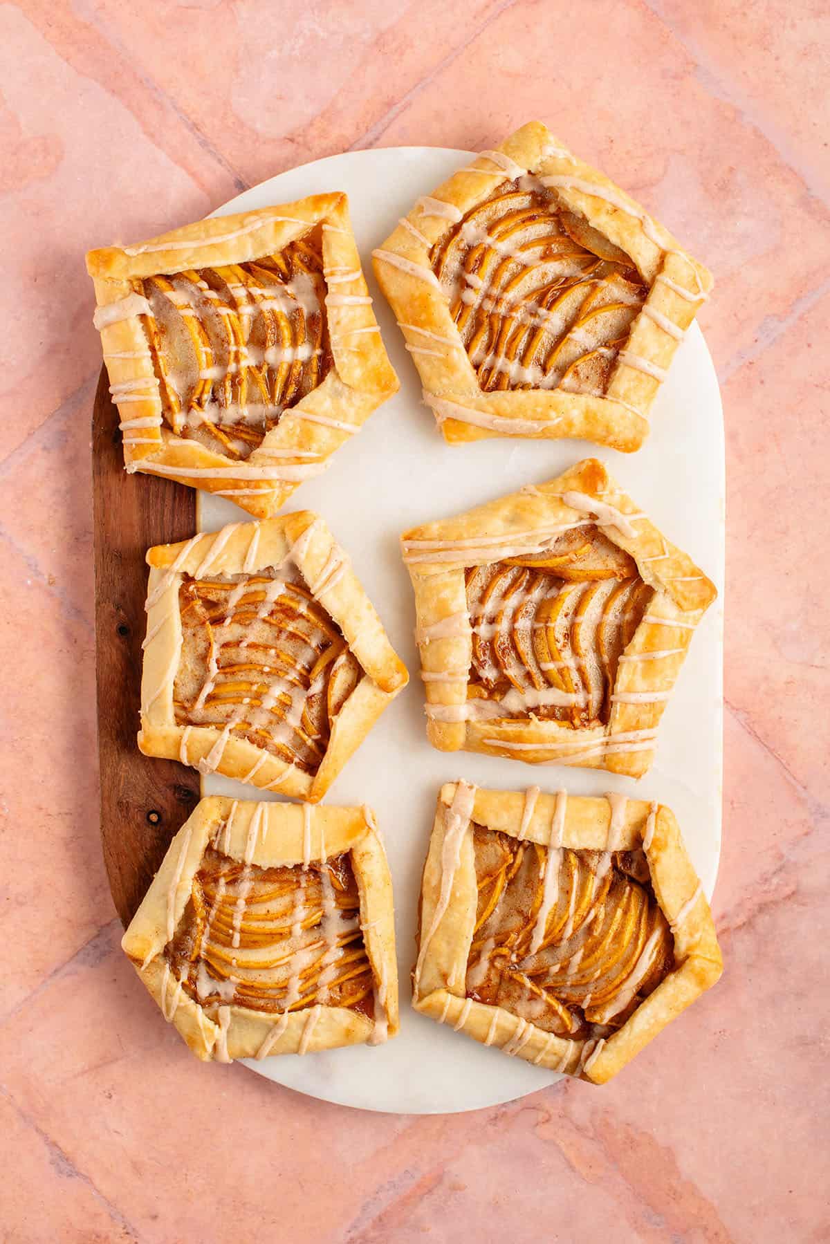 6 Mini Spiced Pear Galettes with maple glaze on marble and wood board