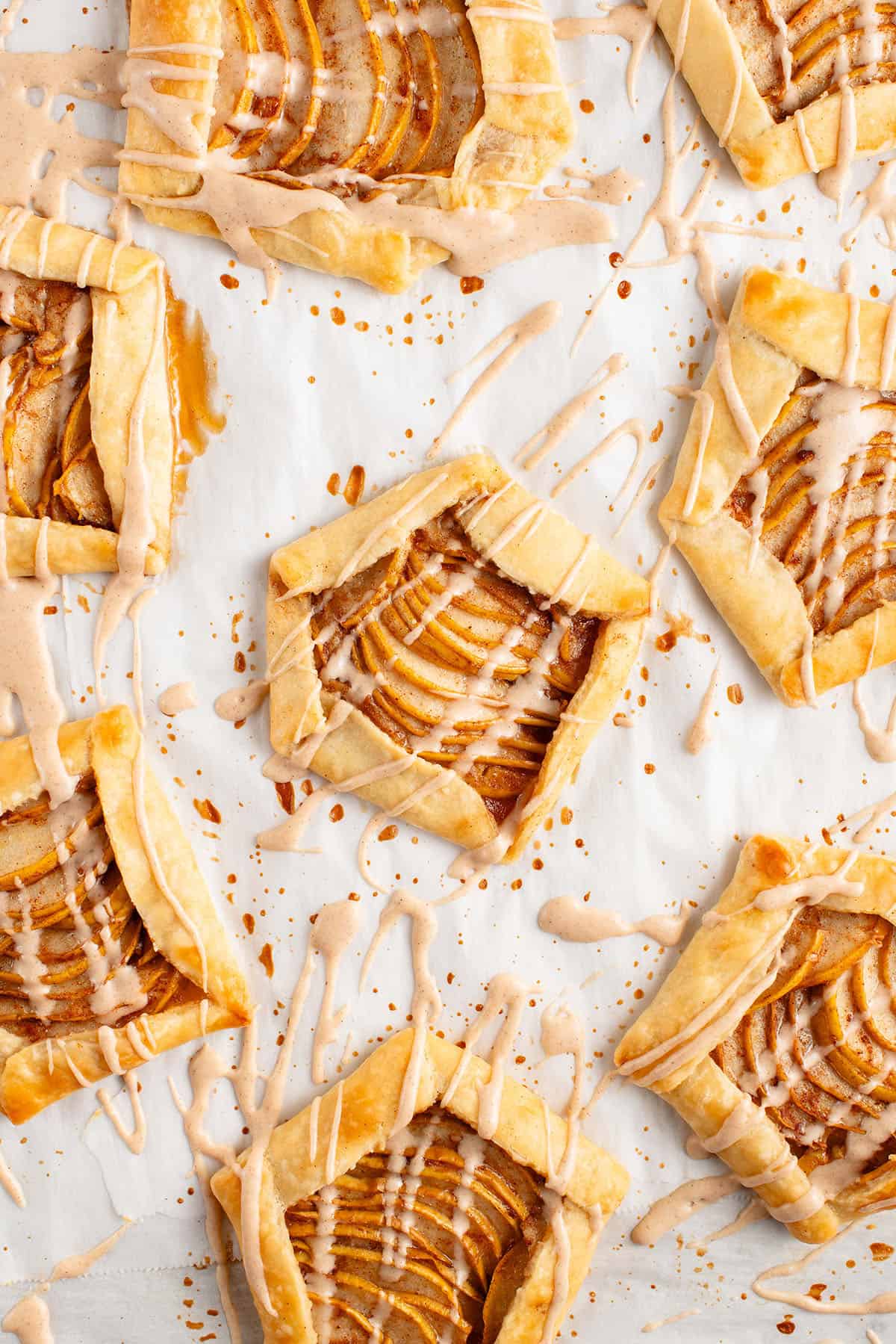 Mini Spiced Pear Galettes with maple glaze on parchment paper